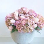 Gift your loved one a pink roses and hydrangea flower arrangement in a cement pot