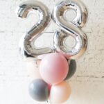His arrangement includes one giant number balloon and five helium latex balloons. The color theme and number can be customized to your preference.