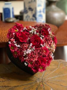 Give your loved one a beautiful heart-shaped arrangement featuring stunning red roses and vibrant red chrysanthemums