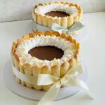 Espresso chocolate mousse charlotte – a rich espresso cake base layered with silky chocolate mousse, wrapped in delicate sponge fingers, measuring 7 inches in diameter and 3-4 inches in height.