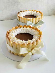 Espresso Chocolate Mousse Charlotte – A rich espresso cake base layered with silky chocolate mousse, wrapped in delicate sponge fingers, measuring 7 inches in diameter and 3-4 inches in height.