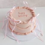 Light pink color cake with baby ribbon. 1kg
