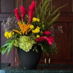 Gift a stunning arrangement of vibrant tropical flowers, lush hydrangeas, and delicate chrysanthemums, accented with exotic foliage and elegantly presented in a sleek black vase. A perfect blend of beauty and sophistication for any occasion