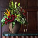 Gift a striking arrangement of maroon chrysanthemums, lush hydrangeas, exotic tropical flowers, and elegant lilies, accented with lush foliage in a sophisticated brown vase. A perfect statement of beauty and elegance for any occasion.